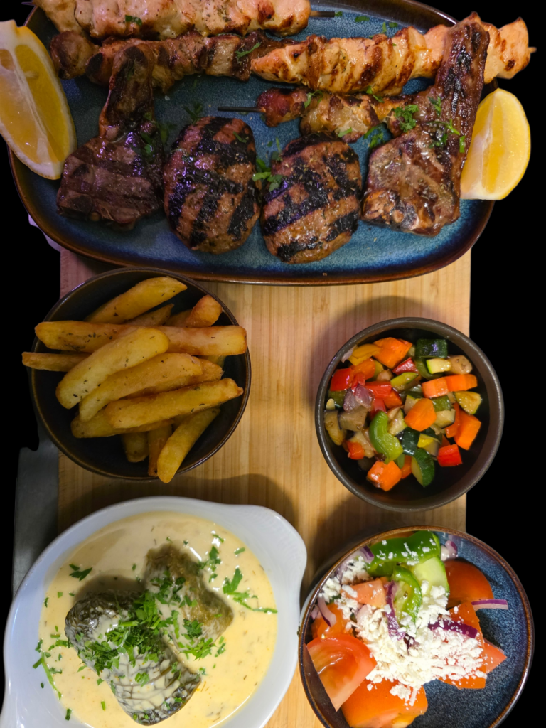 Spécialités grecques - saumon grillé et poisson en sauce, servis dans des bols en céramique